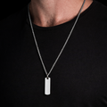 Silver necklace with a pendant on a black shirt