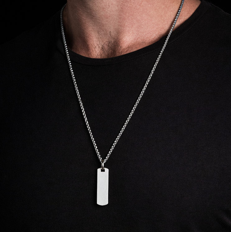 Silver necklace with a pendant on a black shirt
