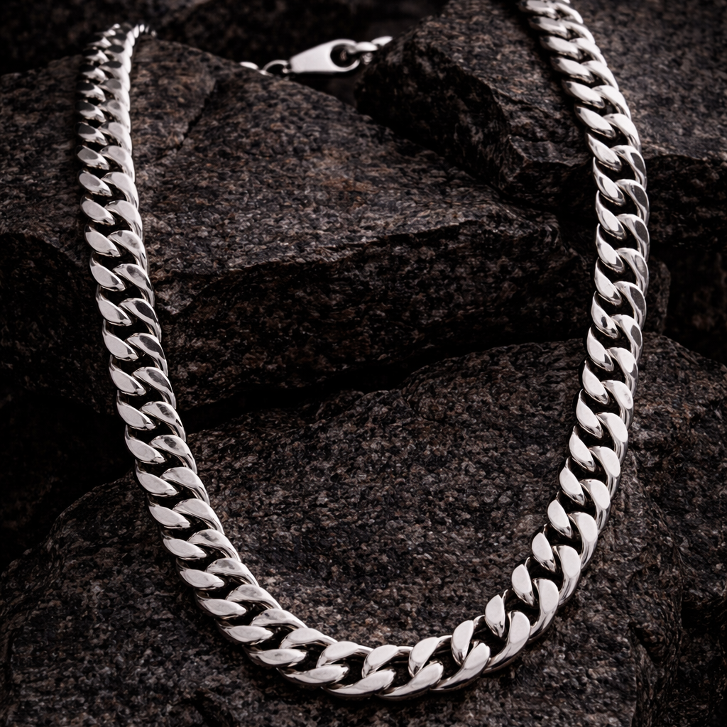 Silver chain necklace on a dark stone surface