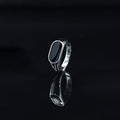 Silver ring with a black stone on a black background